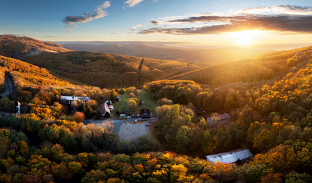Autumn forest and fields in warm evening light, seen from the airの写真素材