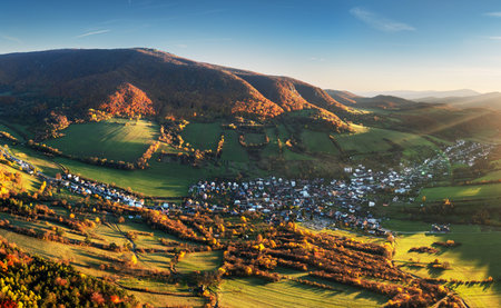 Gorgeous autumn slopes from a bird's eye view are illuminated by warm sunlight. Location place...