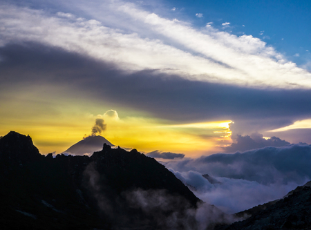 Erupting volcano at sunsetの写真素材