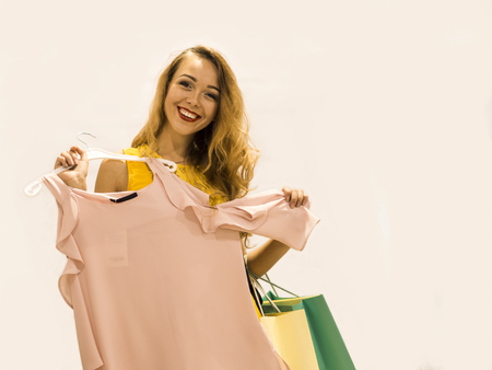 Young Attractive Smiling Girl in Yellow Dress is Measures New Dress in the Mallの写真素材