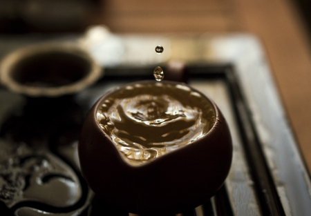 Pouring of Exquisite Green Tea from Teapot at Traditional Chinese Tea Ceremony. Set of Equipment for Drinking Teaの写真素材