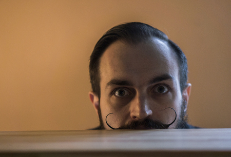 Modern, Expressive Bearded Office Clerk with Mustages Working with Notebook at Officeの写真素材