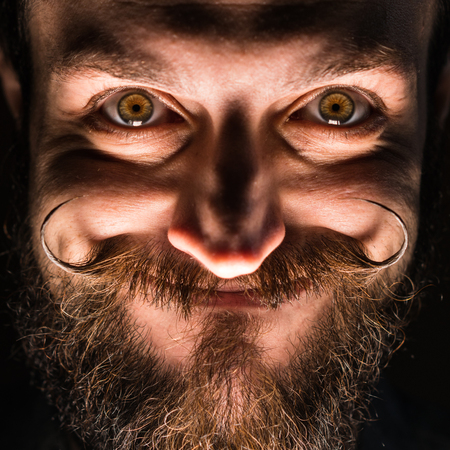 Inventor Hipster with Beard and Mustages in the Dark Room. Smiling Trickster.の写真素材