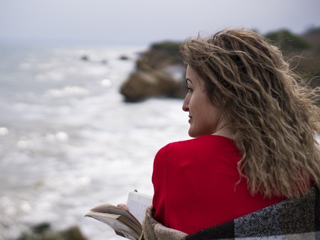 Happy Young Woman in Red Dress Have Fun at the Sea Coast Cliffの写真素材