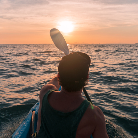 Kayaking. Man With kayak paddle at sunset sea Rowing to the Sun.の写真素材