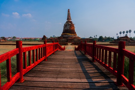 Old Wooden bridge with Red Handrails heading to Ancient Pagoda in Ayutthaya City, Thailand.の写真素材