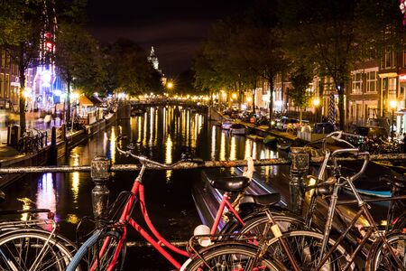 NETHERLANDS, AMSTERDAM - 23 AUG 2018: Night city view of bicycle on Amsterdam bridge and typical dutch houses, Holland, Netherlands.のeditorial素材