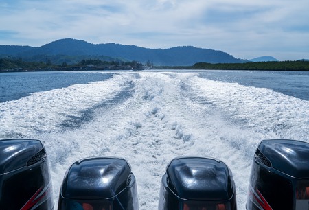 Four Boat motors left a pass of foam on the waterの写真素材