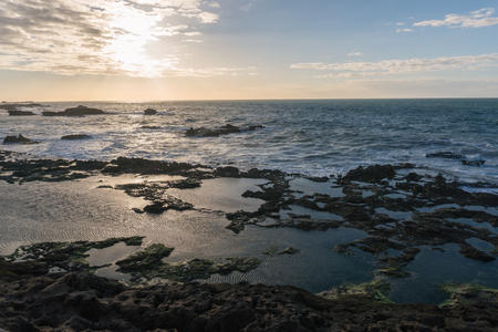 Sunset Over the Rocks of Atlantic Ocean in Morocco at Low Tideの写真素材