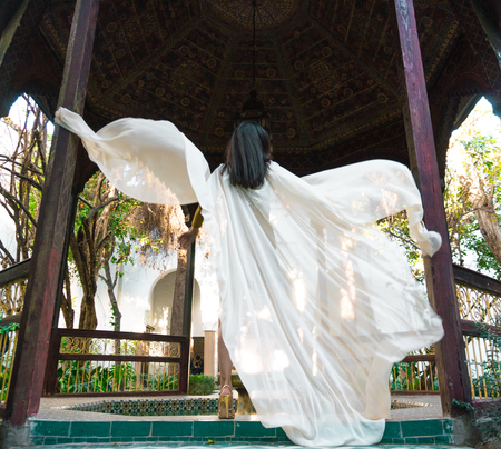 Beautiful Moroccan Girl Waving her white mantle in Rich interior of Picturesque Dar Si Said Riyad in Marrakechの写真素材