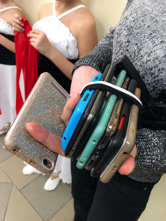 Pile of stacking different mobile phones. Parent mom is carrying Smartphones of performing childrens...