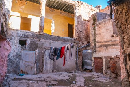 Pink Moroccan facade in City center. Window with drying hanging clothe. Ruins, Poor district. devastation. Lifestyle. In Marrakech the houses are traditionally pink. Moroccoの写真素材