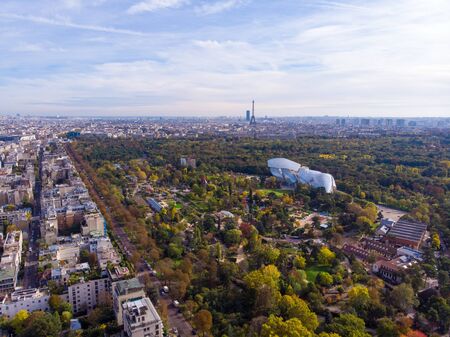 FRANCE, PARIS - OCT 2019: Aerial shot of Louis Vuitton Foundation museum modern building in Paris, France. Eiffel Tower on background, Boulogne forest around.のeditorial素材