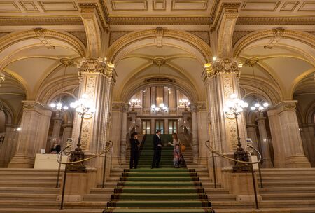 VIENNA, AUSTRIA - OCTOBER 2019: Conversation of tourist girl with opera theatre staff in Vienna State Opera House. Wiener Staatsoper stairs, fresco and rich gold interiorのeditorial素材