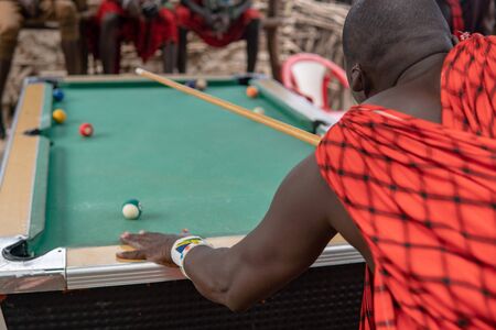 African masai men playing open air billiard pool in the village Sengare Sero at Masailand.の写真素材