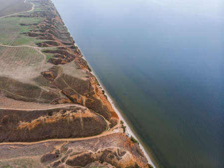 Aerial Shot of clay hills with canyons near the Black sea at Misty Autumn weather. Stanislavs mountains, Kherson region, Ukraineの写真素材