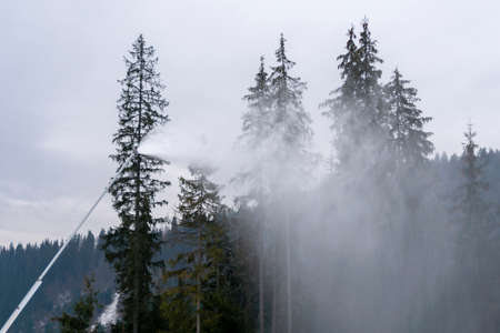 Snow cannon throwing Producting Snowon slope, snowmaker in action at ski resortの写真素材