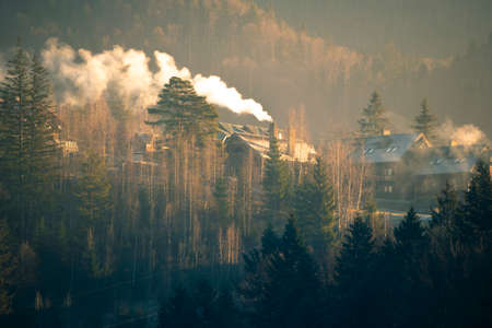 Cozy House in Mountains at Foggy Morning. Misty landscape in the mountains. Fantastic morning glowing by sunlightの写真素材