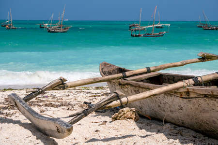Traditional wooden dhow boats on the White Sand Beach with amazing turquoise water in the Indian ocean at Nungwi village, Zanzibar, Tanzaniaの写真素材