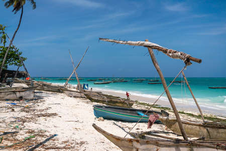 Traditional wooden dhow boats on the White Sand Beach with amazing turquoise water in the Indian ocean at Nungwi village, Zanzibar, Tanzaniaの写真素材