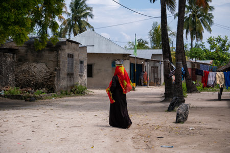 NUNGWI, TANZANIA - January 2020: Nungwi village, Black African Woman on the street of Fisherman Village, Zanzibar, Tanzaniaのeditorial素材