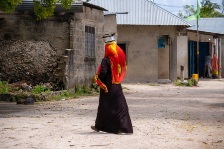 NUNGWI, TANZANIA - January 2020: Nungwi village, Black African Woman on the street of Fisherman Village, Zanzibar, Tanzaniaのeditorial素材