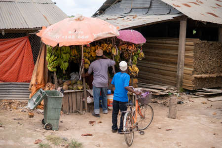 Zanzibar, Tanzania - JANUARY 2020: Black African People Vendors at the Street Fruit and Goods Shop stall Point on Village Streets of Zanzibarのeditorial素材