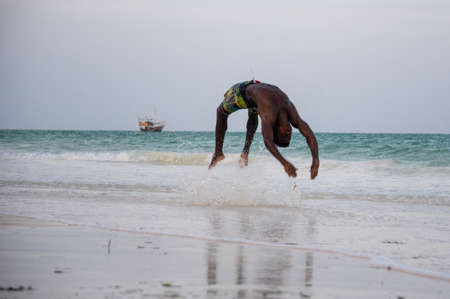 Young Attractive Muscular and Strong Athletic Black African Man at the White Sand Beach Training Body Calisthenicsの写真素材