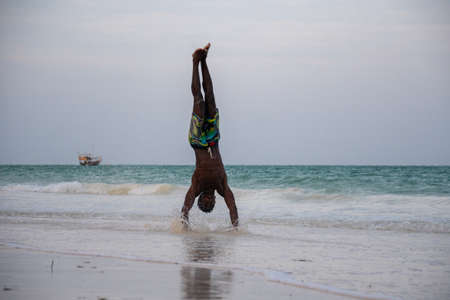 Young Attractive Muscular and Strong Athletic Black African Man at the White Sand Beach Training Body Calisthenicsの写真素材