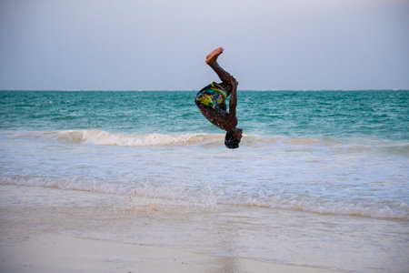 Young Attractive Muscular and Strong Athletic Black African Man at the White Sand Beach Training Body Calisthenicsの写真素材