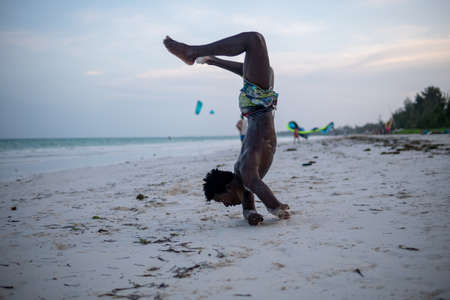Young Attractive Muscular and Strong Athletic Black African Man at the White Sand Beach Training Body Calisthenicsの写真素材