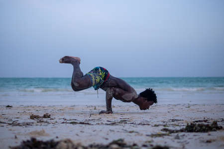 Young Attractive Muscular and Strong Athletic Black African Man at the White Sand Beach Training Body Calisthenicsの写真素材