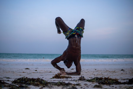 Young Attractive Muscular and Strong Athletic Black African Man at the White Sand Beach Training Body Calisthenicsの写真素材