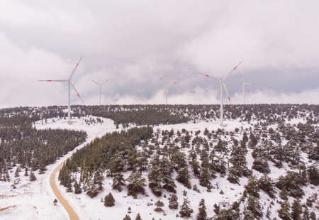 Aerial Shot of Wind Turbine farm At Snowy Highlands in Turkey at Cloudy spring dayの写真素材