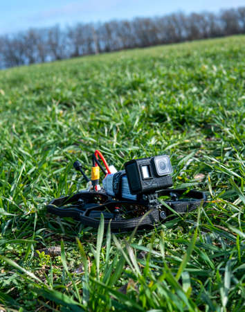 A Brand-New Modern Cinewhoop Iflight Protek 35 with  Action Camera on Board Outdoors in the Grassの写真素材