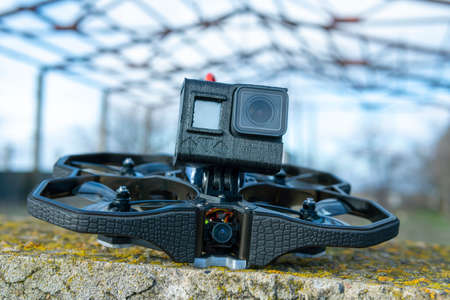 A Brand-New Modern Cinewhoop Inflight Protek 35 with  Action Camera on Board Outdoors in the Grassの写真素材