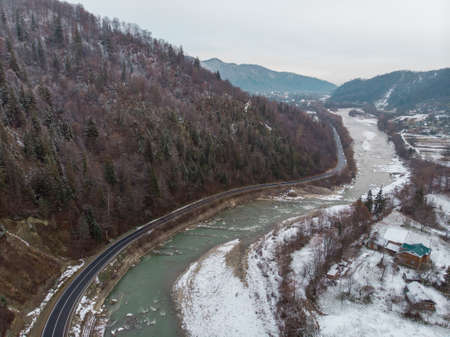 Wonderful landscapes of the Carpathian Mountains covered with snow at Cloudy Day in Ukraine near the village of Vyzhnytsia and River Cheremoshの写真素材