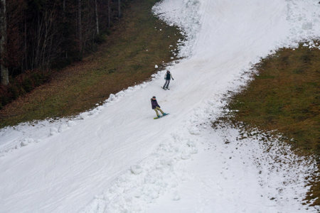 Two Snowboarders riding on Artificial White Snow Covered Slope top viewの写真素材