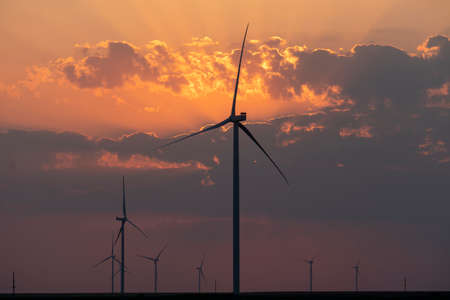 Silhouettes of wind turbines farm Behind the Lake at Sunset.の写真素材