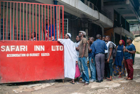 DAR ES SALAAM, TANZANIA - JANUARY 2020: Group of African People Are wathing Football on the street, Big queue Crowd on the street. Many people wath one small TVのeditorial素材
