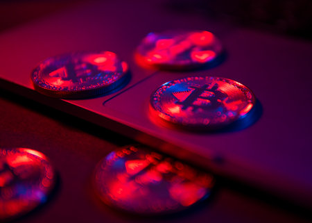 The coins of Bitcoin are on the laptop Surface. Purple and pink neon lightの写真素材