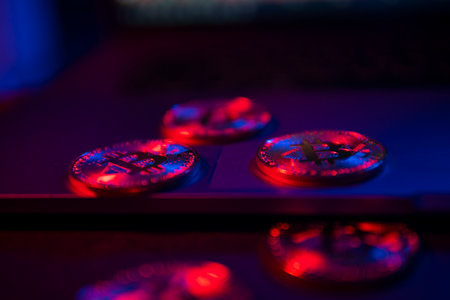 The coins of Bitcoin are on the laptop Surface. Purple and pink neon lightの写真素材