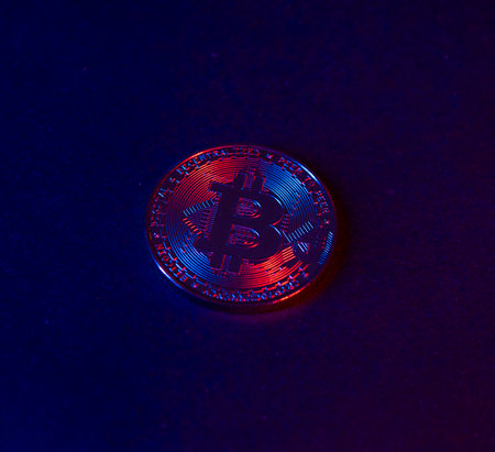 The coin of Bitcoin are on a dark Surface. Purple and pink neon lightの写真素材