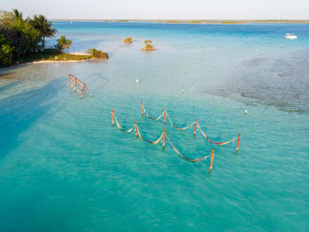 Cenote Cocalitos. Swings and Hammocks in turquoise water of seven colores lagoon near Bacalar, Quintana Roo, Mexicoの写真素材