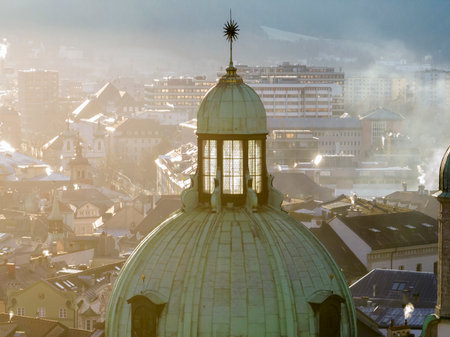 Bell towers of Cathedral of St. James in Innsbruck, Austria. Church Domes in Soaft Light at Foggy Evening sunset timeの写真素材