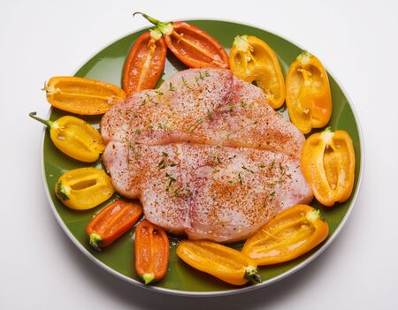 plate of swordfish steaks and baby bell peppers ready for grillingの写真素材