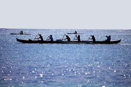 Silhouette of women paddling an outrigger canoeの写真素材