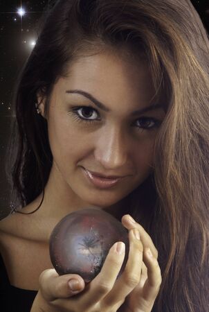 young woman with a crystal ball with a tropical scene inside