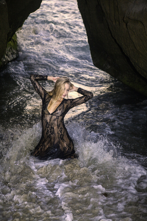 beautiful blond woman on seaside rocksの写真素材
