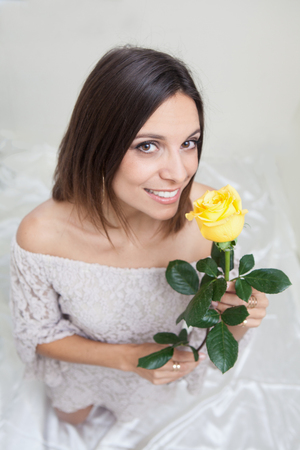 portrait of a beautiful woman with yellow roseの写真素材